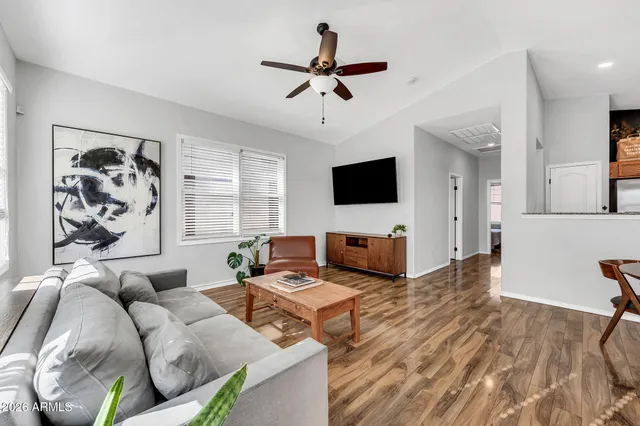 a living room with furniture kitchen view and a window