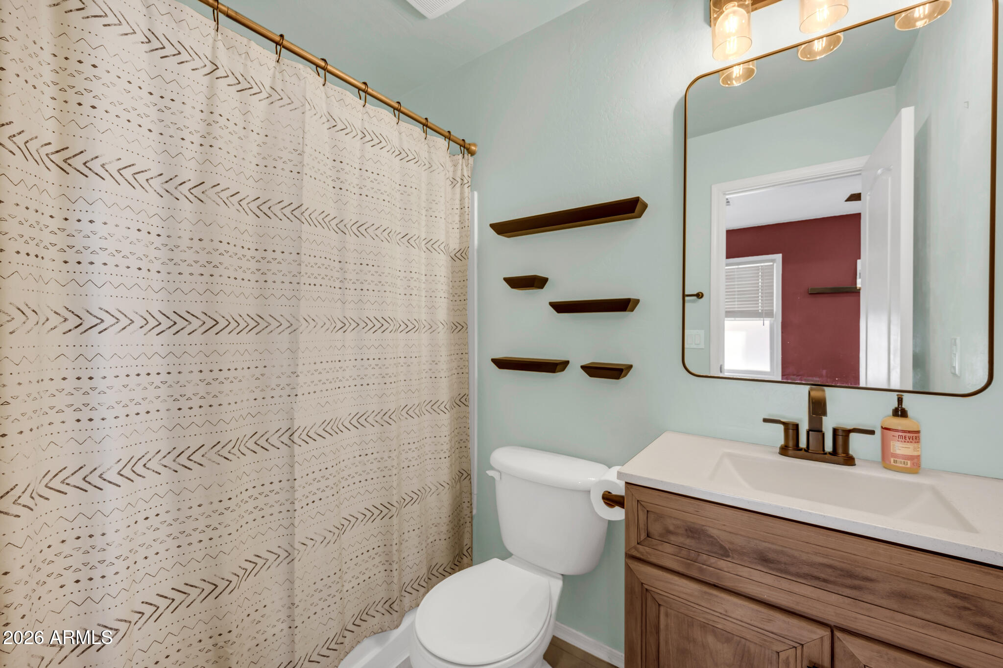 5627 South 21st Terrace Phoenix, AZ 85040 - Photo 19 of 32 a bathroom with a sink a toilet and shower curtain