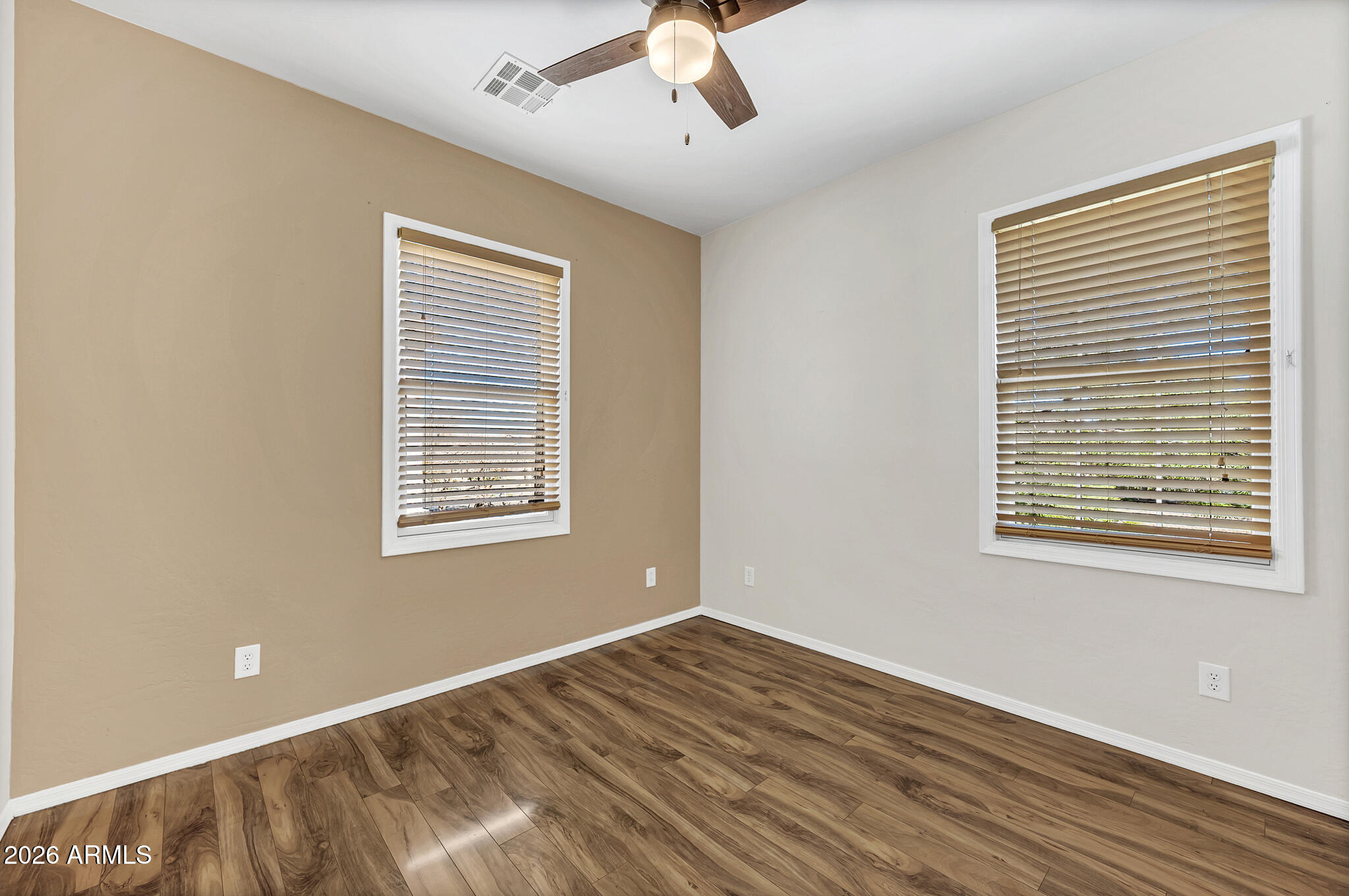 5627 South 21st Terrace Phoenix, AZ 85040 - Photo 22 of 32 a view of an empty room with wooden floor and a window
