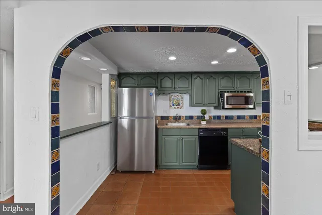 a kitchen with refrigerator and microwave