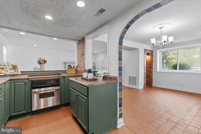 a kitchen with kitchen island granite countertop a sink cabinets and stainless steel appliances