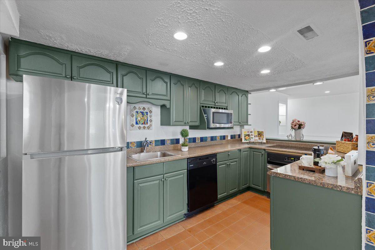 202 Buckingham Lane, Unit 102 Stafford, VA 22556 - Photo 14 of 37 a kitchen with kitchen island stainless steel appliances a sink stove and refrigerator