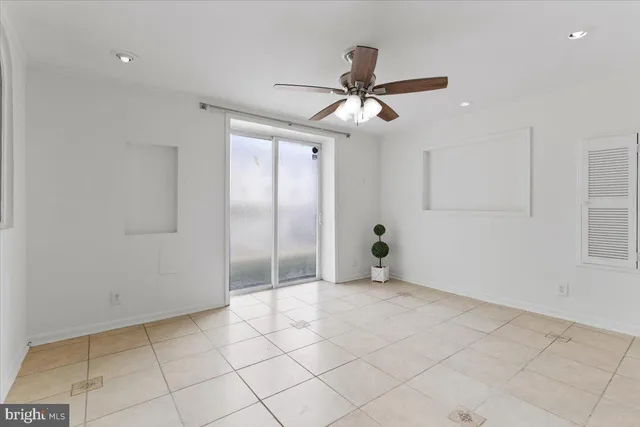 a view of an empty room and window a ceiling fan