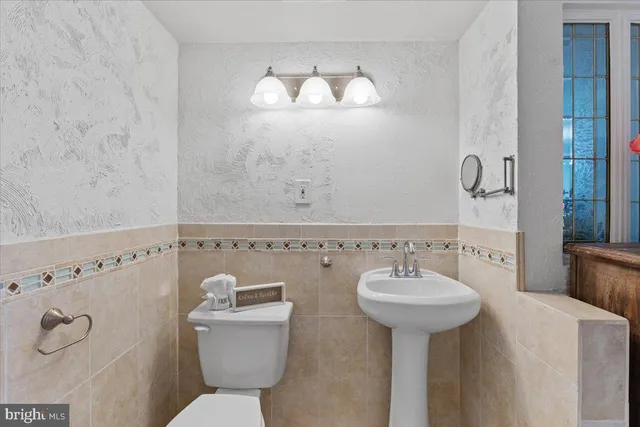 a bathroom with a sink a toilet and a mirror