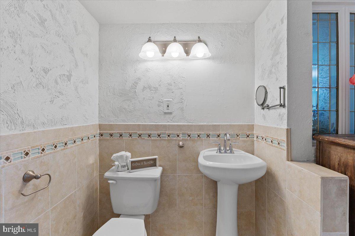 202 Buckingham Lane, Unit 102 Stafford, VA 22556 - Photo 22 of 37 a bathroom with a sink a toilet and a mirror