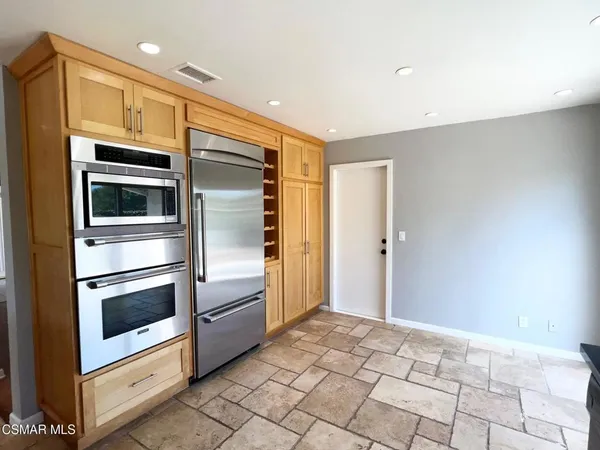 a kitchen with granite countertop a refrigerator and a stove top oven