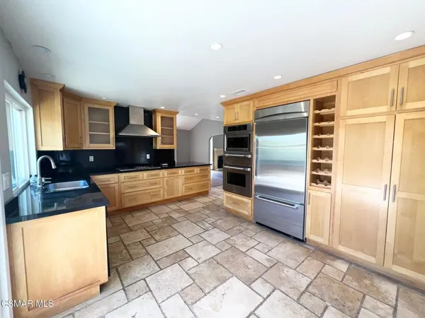 a large kitchen with kitchen island granite countertop a large window and a counter top space