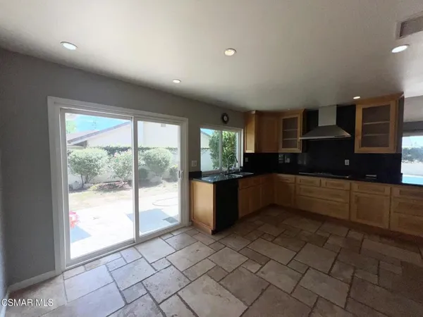 a kitchen with granite countertop a refrigerator and a sink