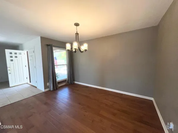 a view of a room with wooden floor and ceiling fan
