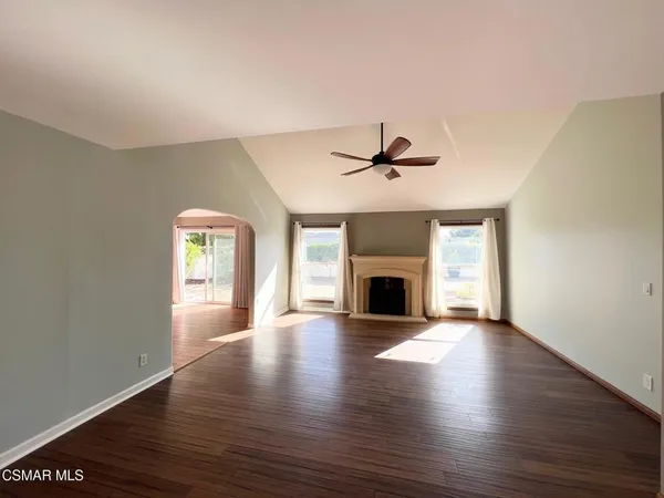 a view of an empty room with a fireplace and a window