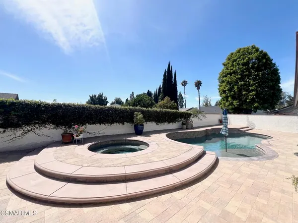 a view of a yard with plants and a fountain