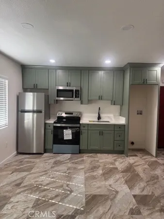 a kitchen with stainless steel appliances granite countertop a refrigerator and a sink