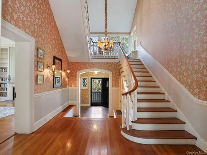 a view of a hallway with wooden floor and staircase