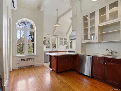 a large kitchen with stainless steel appliances granite countertop a lot of cabinets and wooden floor