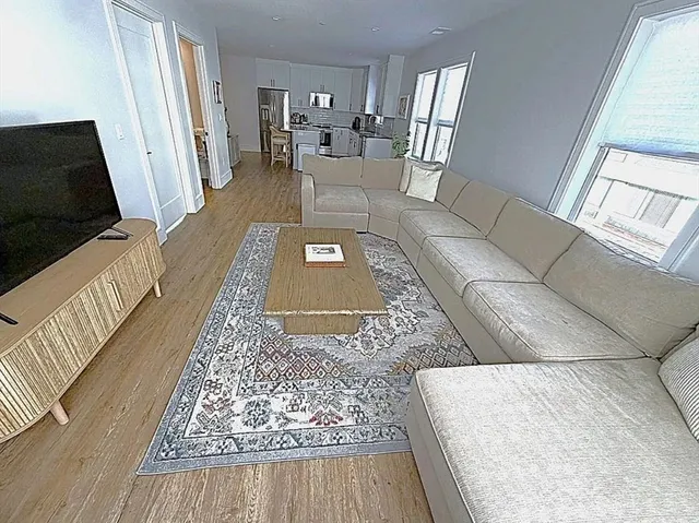 a living room with furniture rug and wooden floor