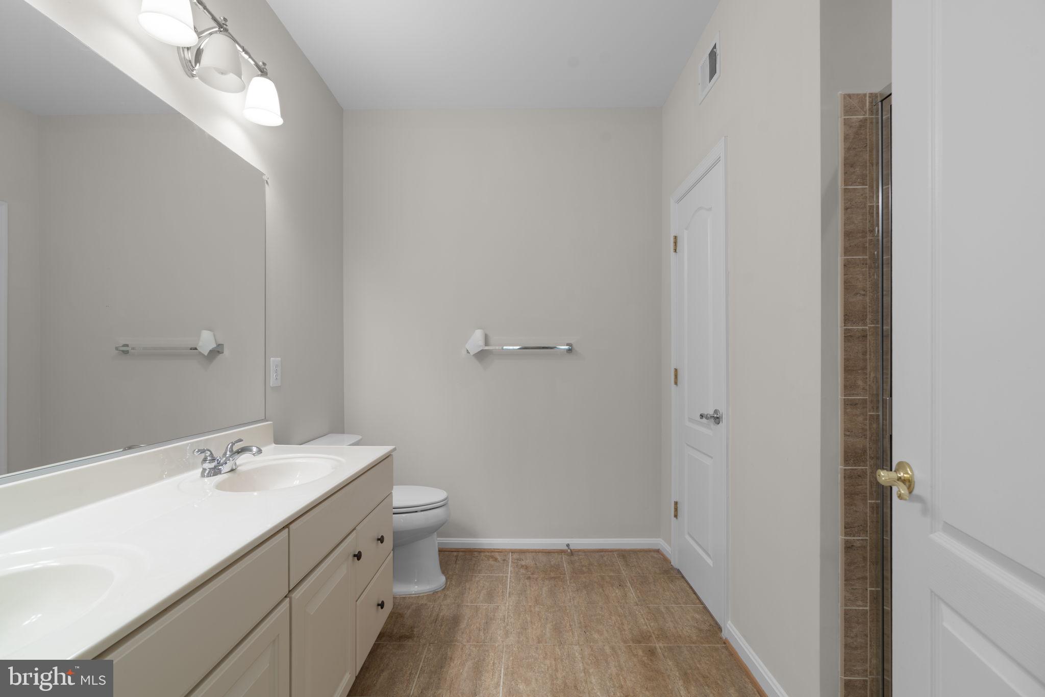 7315 Maplecrest Road, Unit 104 Elkridge, MD 21075 - Photo 33 of 58 a bathroom with a double vanity sink and a mirror