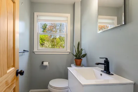 a bathroom with a sink mirror and toilet