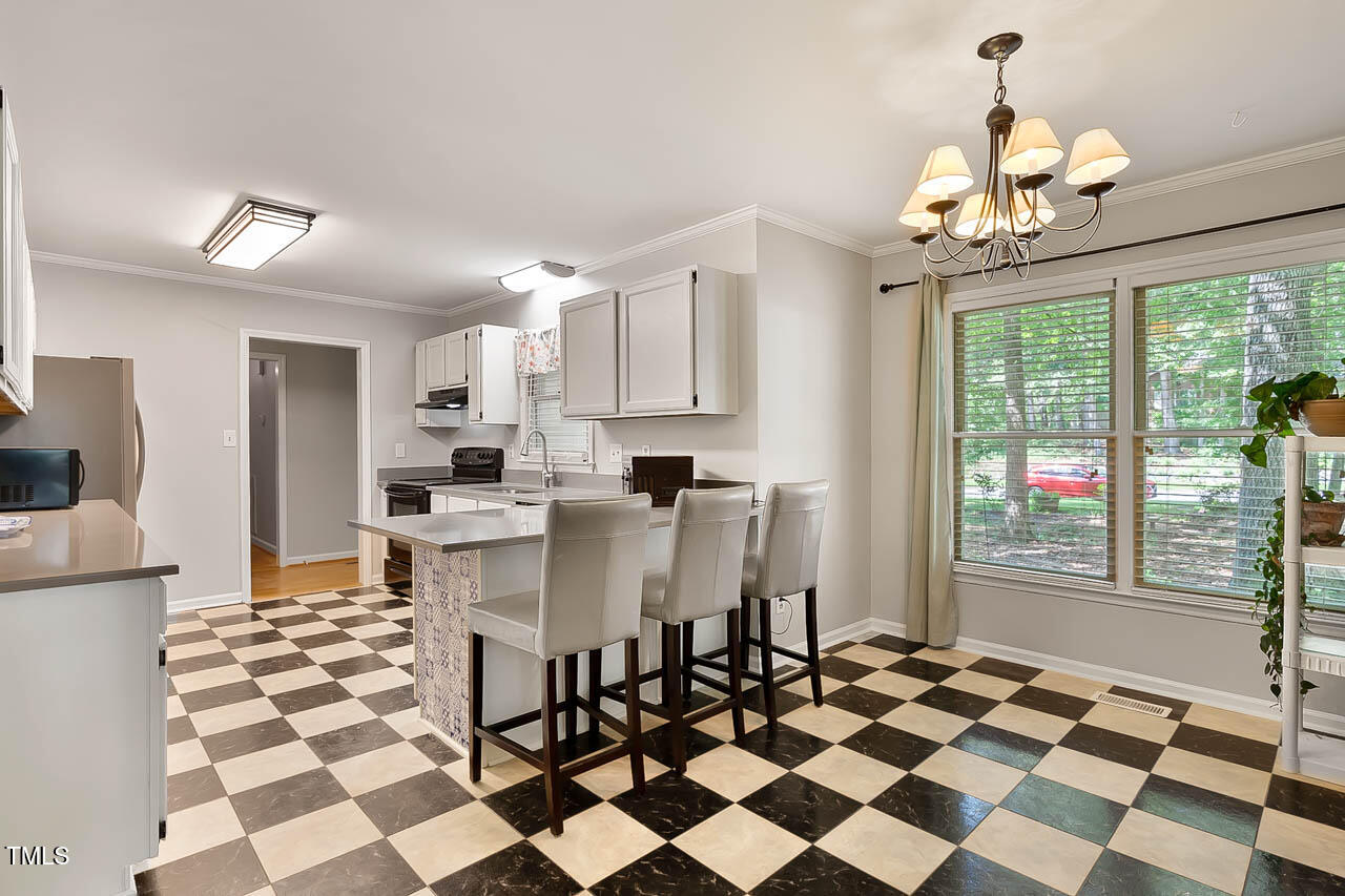 5525 Middleton Road Durham, NC 27713 - Photo 20 of 38 a kitchen with a checkered center island and stainless steel appliances