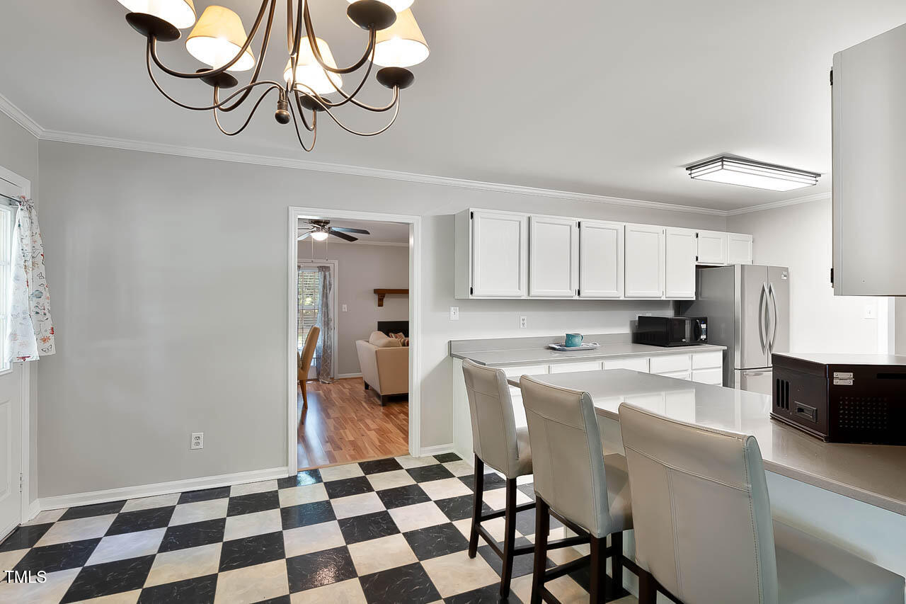 5525 Middleton Road Durham, NC 27713 - Photo 21 of 38 a kitchen with stainless steel appliances granite countertop a refrigerator a microwave oven with white cabinets