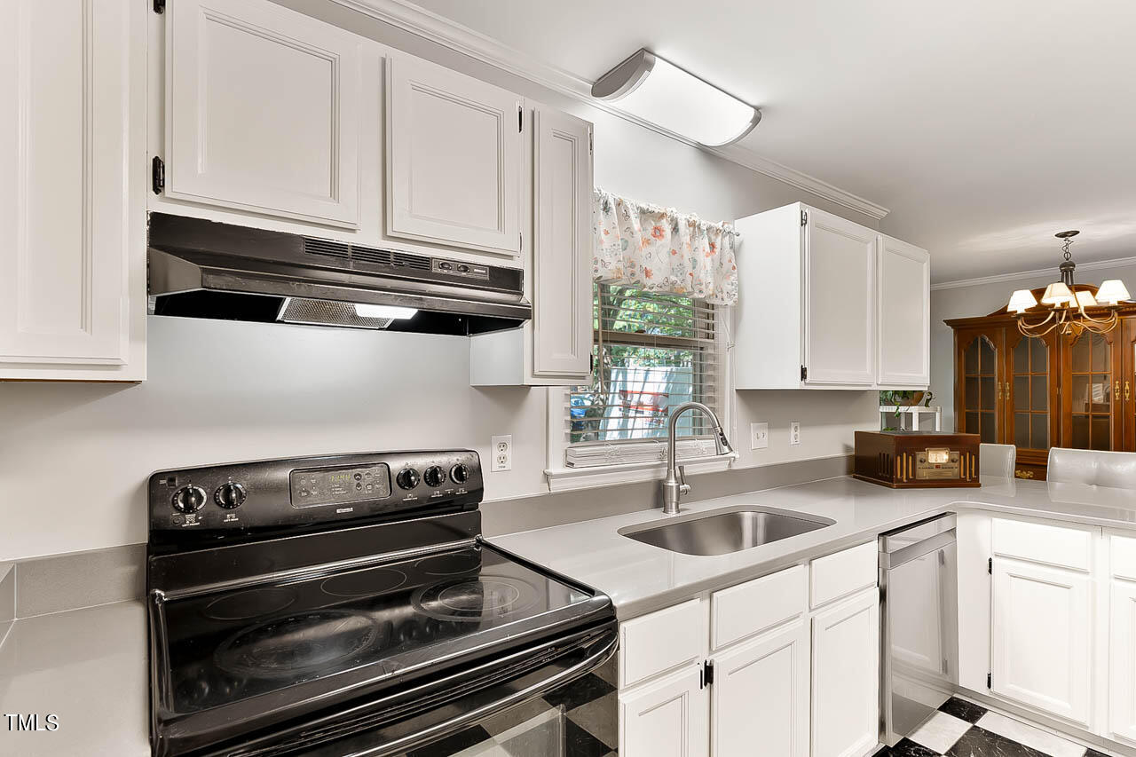 5525 Middleton Road Durham, NC 27713 - Photo 24 of 38 a kitchen with appliances a sink a window and cabinets