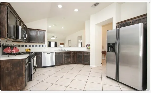 a kitchen with stainless steel appliances a refrigerator sink and cabinets
