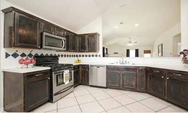 a kitchen with stainless steel appliances granite countertop a stove top oven microwave and cabinets
