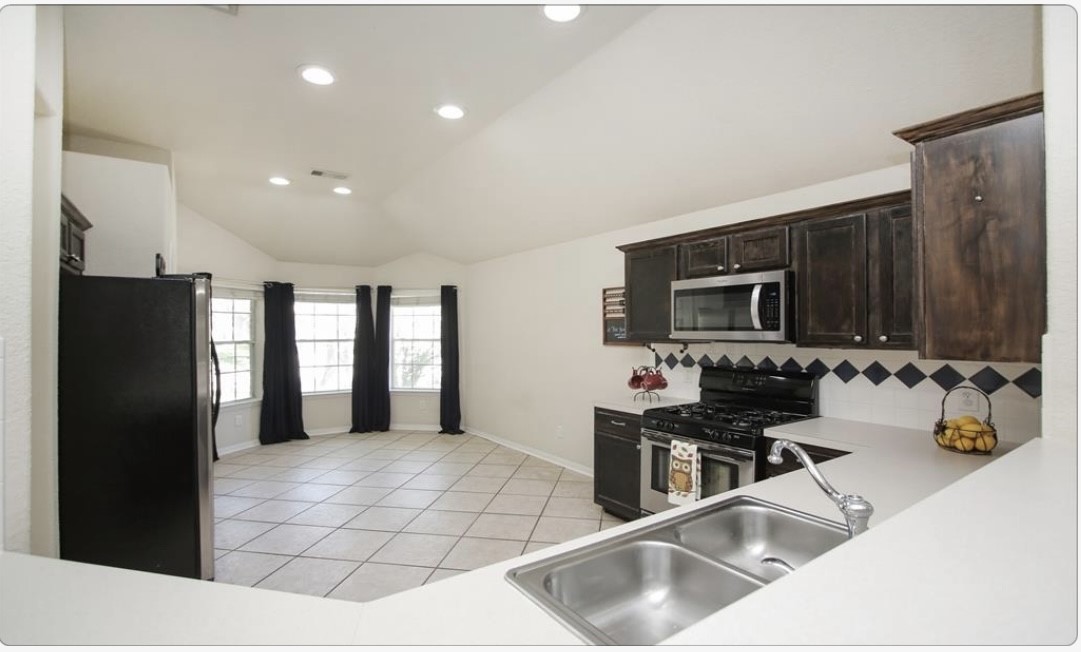 12006 Cyprus Field Houston, TX 77070 - Photo 5 of 7 a kitchen with stainless steel appliances kitchen island granite countertop a refrigerator and a sink