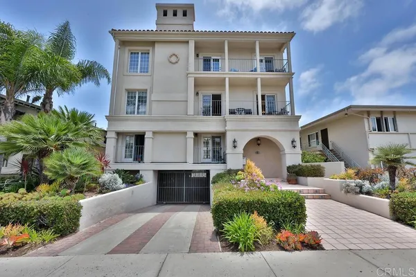 a front view of a house with yard and parking