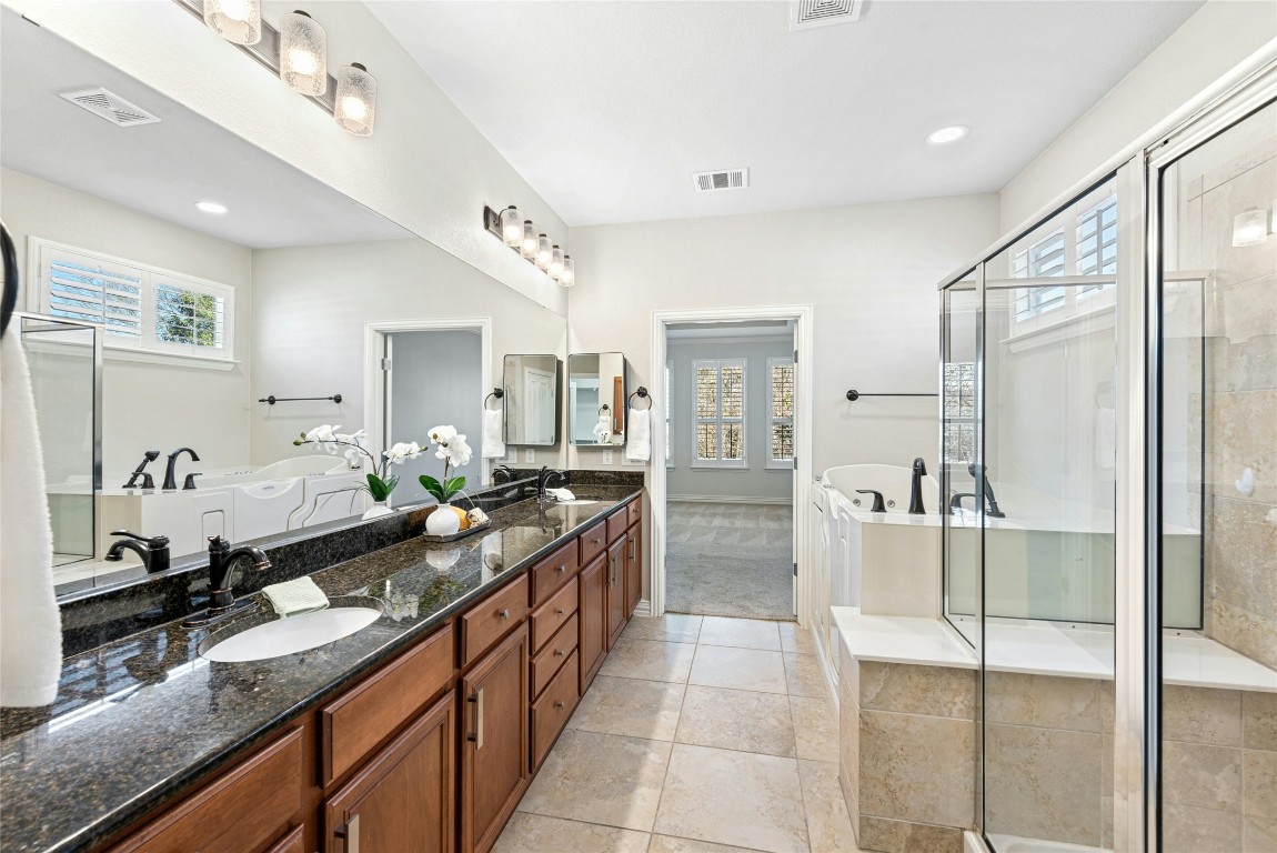 310 Pipe Creek Lane Georgetown, TX 78633 - Photo 17 of 35 a large bathroom with a granite countertop double vanity sink a mirror and a shower