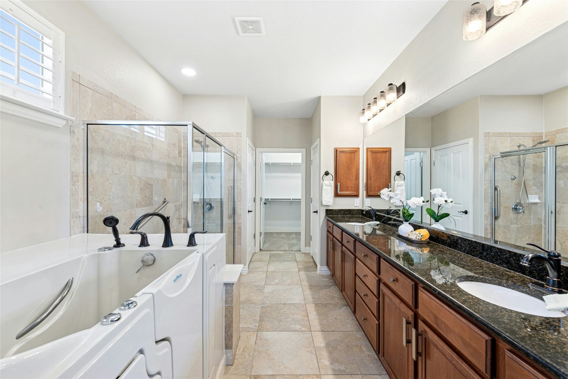 310 Pipe Creek Lane Georgetown, TX 78633 - Photo 18 of 35 a large bathroom with a granite countertop double vanity sink a mirror a shower and a bathtub