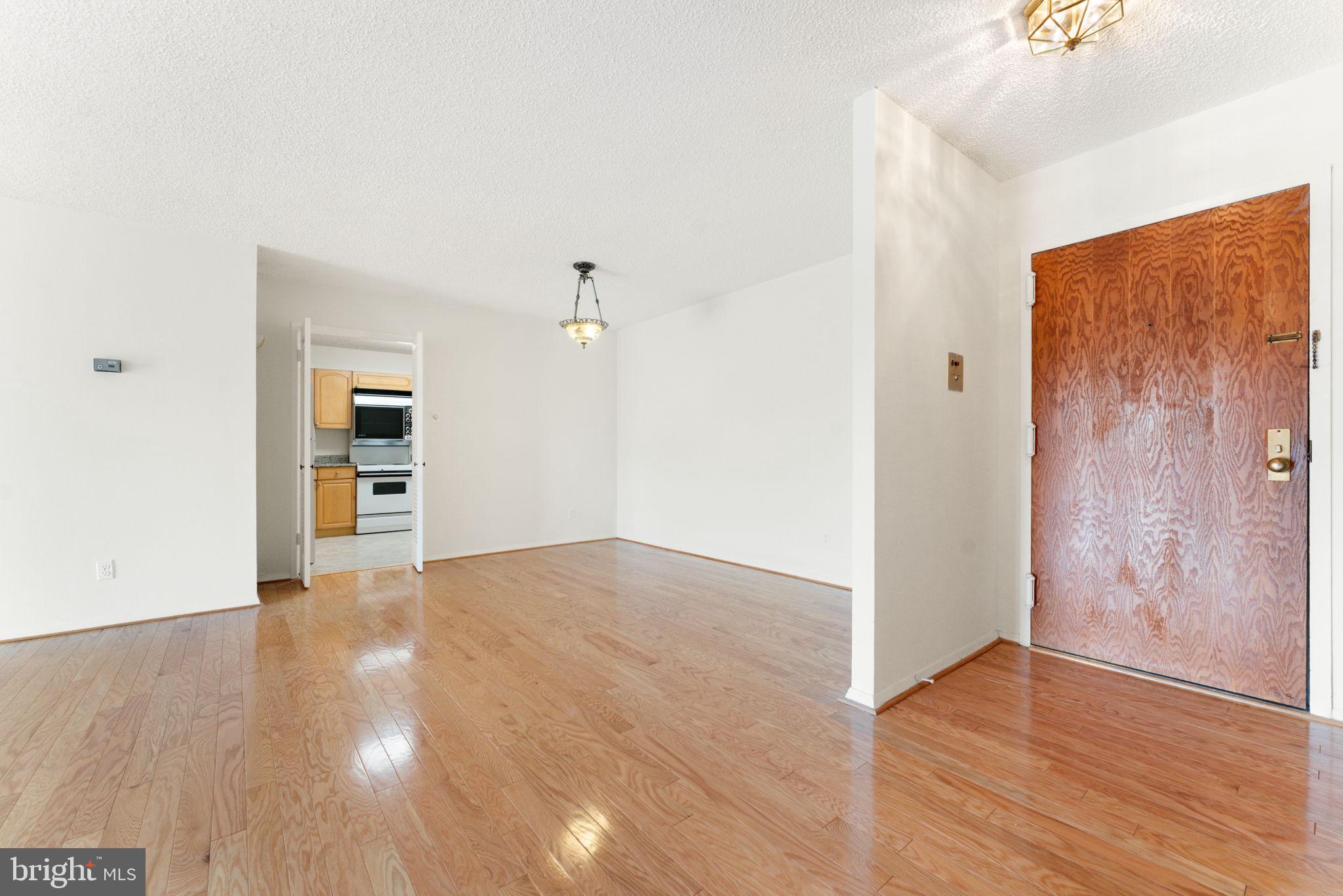 1800 Old Meadow Road, Unit 1218 McLean, VA 22102 - Photo 22 of 55 a view of an empty room with wooden floor and a window