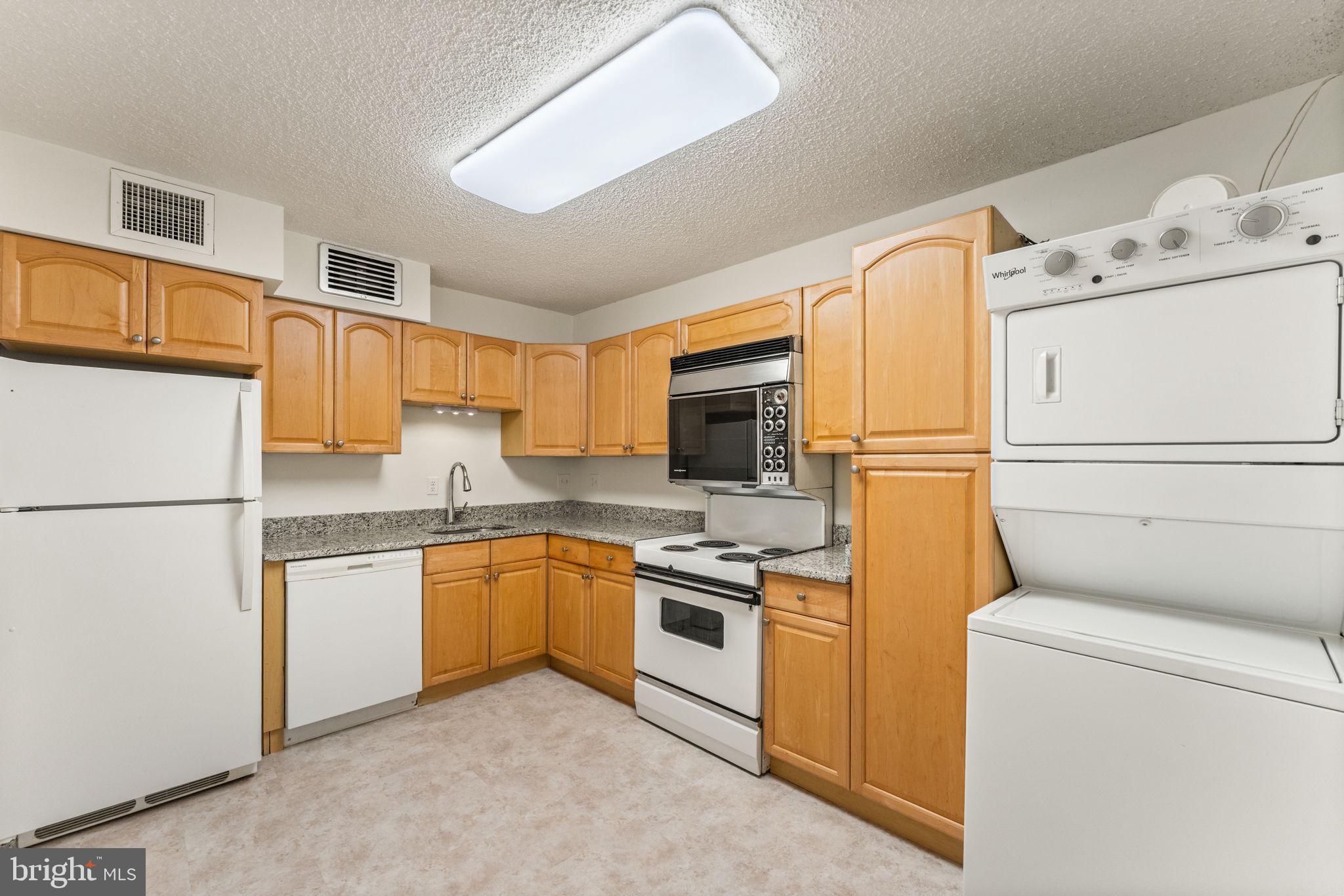 1800 Old Meadow Road, Unit 1218 McLean, VA 22102 - Photo 25 of 55 a kitchen with a white cabinets and white appliances