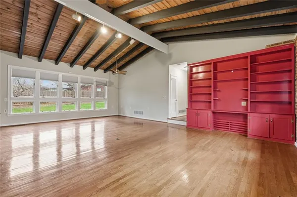 a view of a hallway with wooden floor and closet