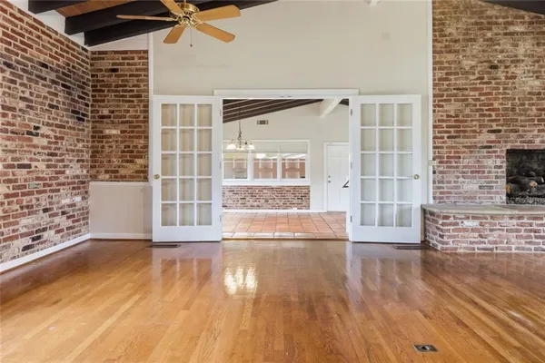 a view of a room with wooden floor and brick walls