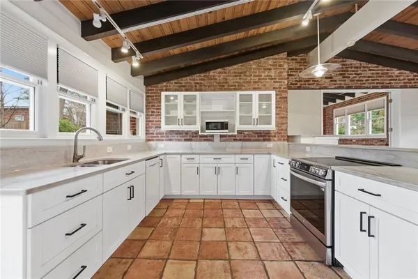 a kitchen with stainless steel appliances granite countertop a sink stove and cabinets