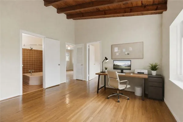 a view of an empty room with a window and wooden floor