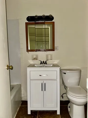 a bathroom with a toilet sink and mirror