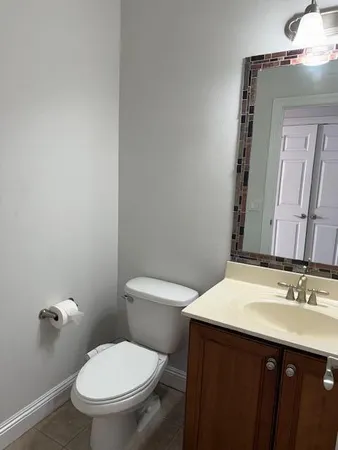 a bathroom with a sink vanity mirror and toilet