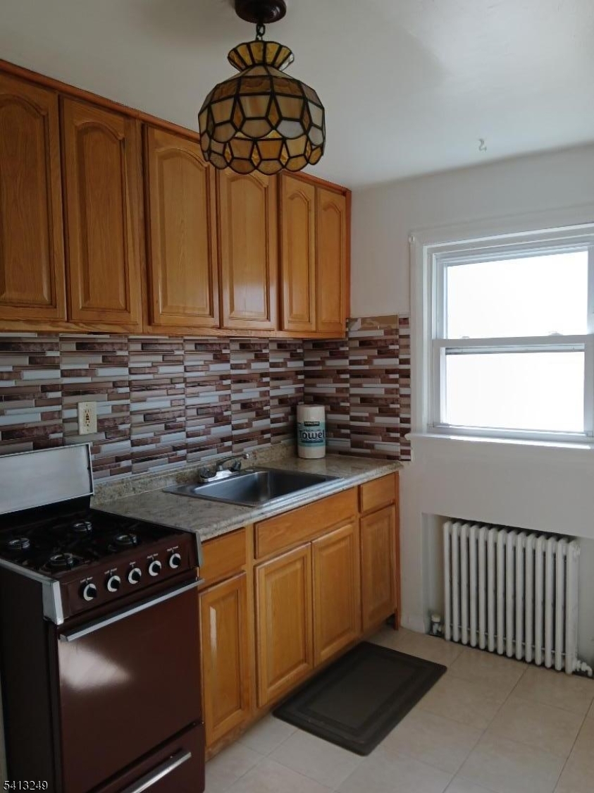 97 Main Avenue, Unit 2 Passaic, NJ 07055 - Photo 2 of 10 a kitchen with stainless steel appliances a stove a sink and a window