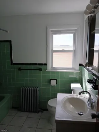 a bathroom with a sink toilet and window