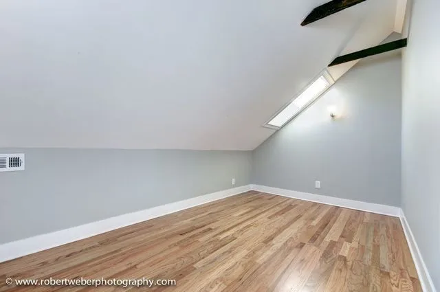 a view of empty room with wooden floor