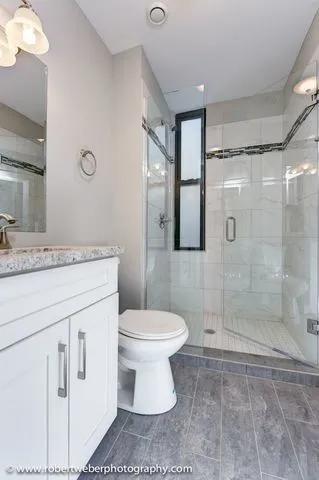 a bathroom with a sink toilet vanity and shower