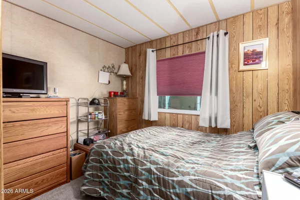 a bedroom with a bed and a flat tv screen