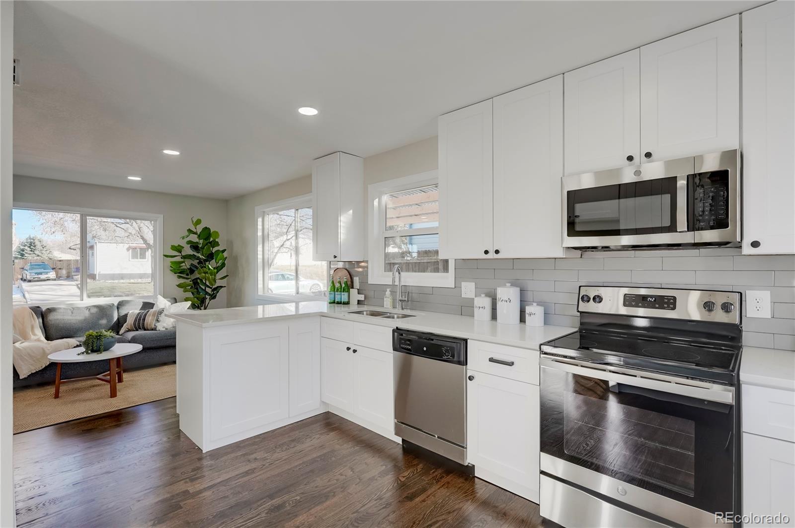 1635 South Raritan Street Denver, CO 80223 - Photo 1 of 17 a kitchen with stainless steel appliances a stove microwave and sink