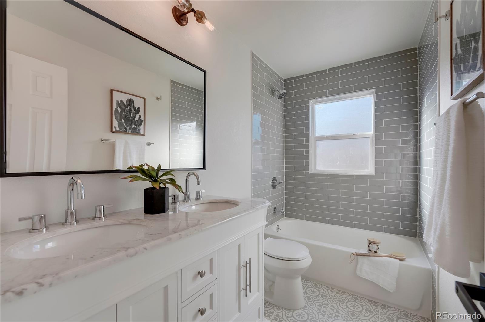 1635 South Raritan Street Denver, CO 80223 - Photo 7 of 17 a bathroom with a granite countertop toilet sink and mirror