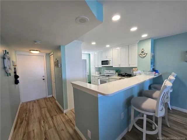 a kitchen with kitchen island a stove a table and chairs in it
