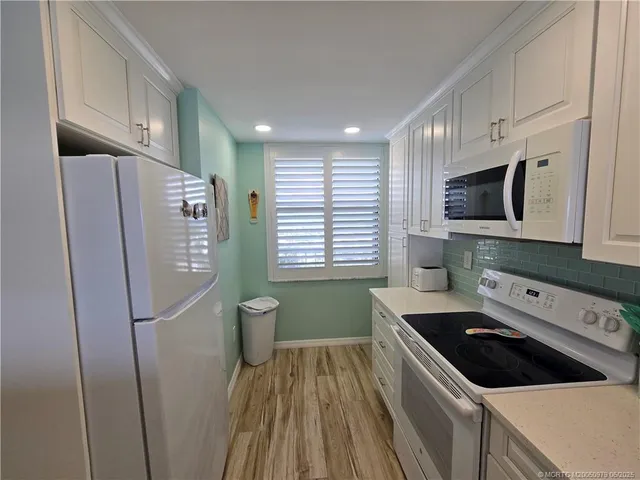 a kitchen with a refrigerator a sink and cabinets