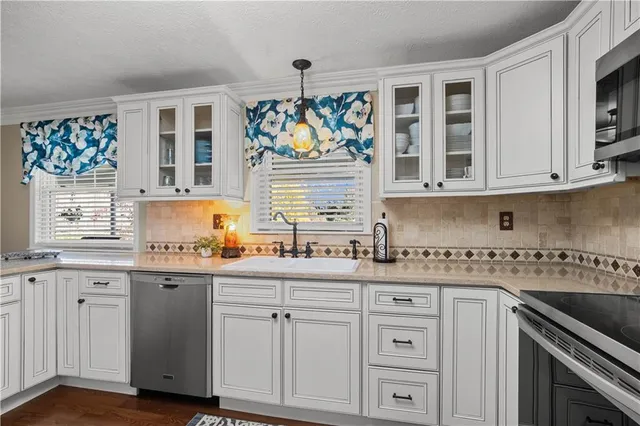 a kitchen with stainless steel appliances granite countertop a sink and cabinets