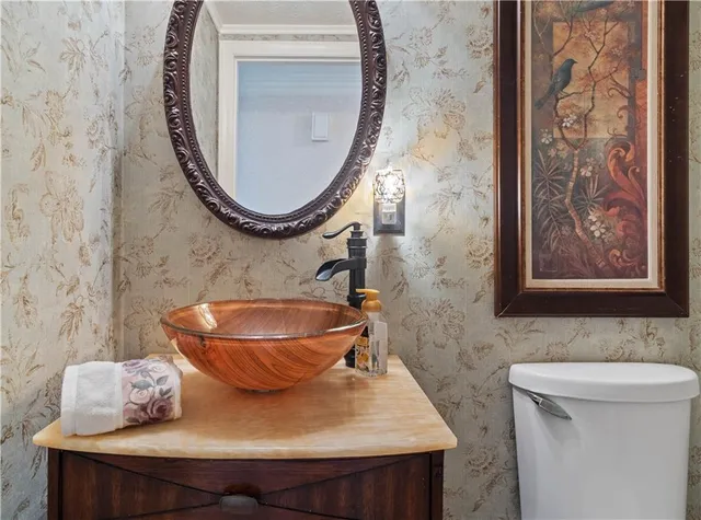 a bathroom with a toilet a sink and a mirror