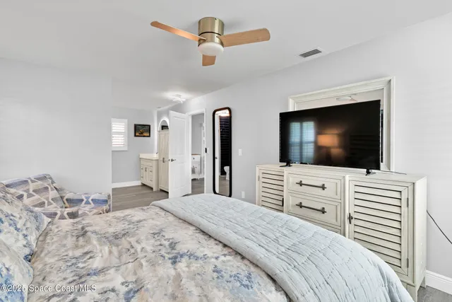 a bedroom with a bed and a flat screen tv in white walls